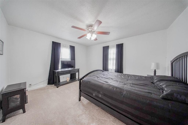 1707 S Mcarthur Ave, Salem, MO 65560 - bedroom featuring carpet, a wood stove, a textured ceiling, ceiling fan, and baseboards