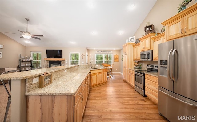 17050 Appaloosa Way, Rolla, MO 65401 - kitchen featuring stainless steel appliances, lofted ceiling, light brown cabinetry, a ceiling fan, and light wood-type flooring
