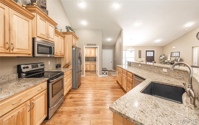 17050 Appaloosa Way, Rolla, MO 65401 - kitchen with stainless steel appliances, a sink, light brown cabinets, vaulted ceiling, and light wood-style floors