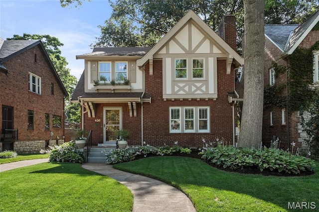 436 W Point Ct, Saint Louis, MO 63130 - tudor home featuring a front lawn, a chimney, and brick siding