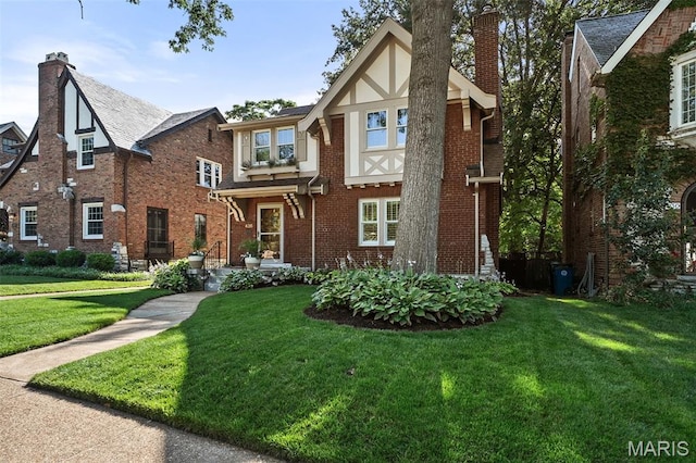 436 W Point Ct, Saint Louis, MO 63130 - tudor house featuring a chimney, a front yard, and brick siding