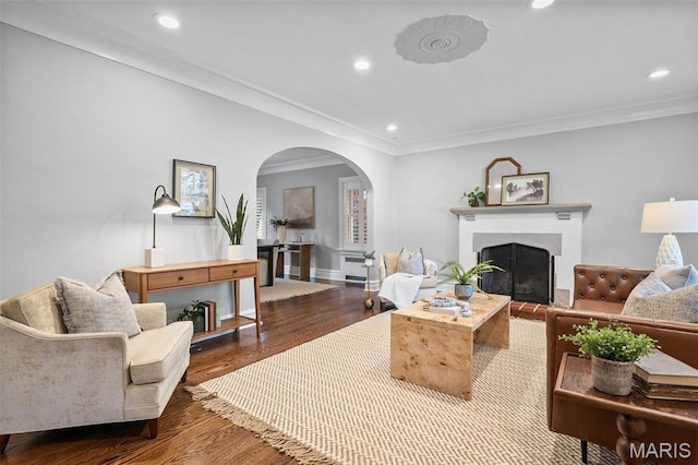 436 W Point Ct, Saint Louis, MO 63130 - living room with arched walkways, wood finished floors, a fireplace with raised hearth, recessed lighting, and crown molding