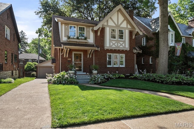 436 W Point Ct, Saint Louis, MO 63130 - tudor-style house with brick siding, an outdoor structure, a front yard, a detached garage, and a chimney