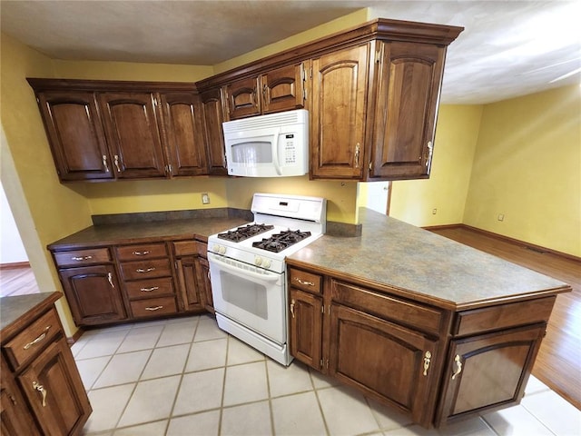 103 Northview Dr, Collinsville, IL 62234 - kitchen with white appliances, dark countertops, and a peninsula