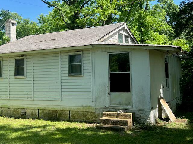 8048 Riverview Dr, Dittmer, MO 63023 - view of home's exterior with crawl space, a chimney, a lawn, and entry steps