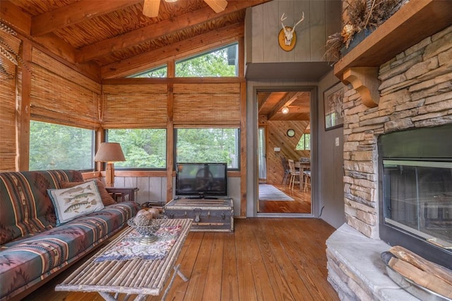 2441 Alpine Lake Dr, Innsbrook, MO 63390 - living area featuring wood walls, hardwood / wood-style floors, plenty of natural light, a stone fireplace, and wooden ceiling with exposed beams