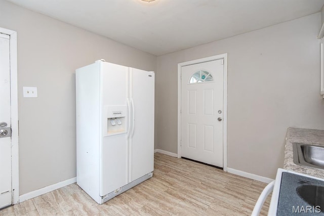 190 Anistasia Dr, Saint Louis, MO 63135 - kitchen featuring white refrigerator with ice dispenser, light wood-style floors, baseboards, and light countertops