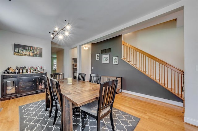 2628 Indiana Ave, Saint Louis, MO 63118 - dining space with wood finished floors, a chandelier, stairs, and baseboards