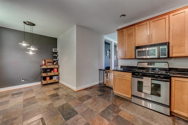 2628 Indiana Ave, Saint Louis, MO 63118 - kitchen with appliances with stainless steel finishes, dark countertops, baseboards, dark stone finish flooring, and pendant lighting