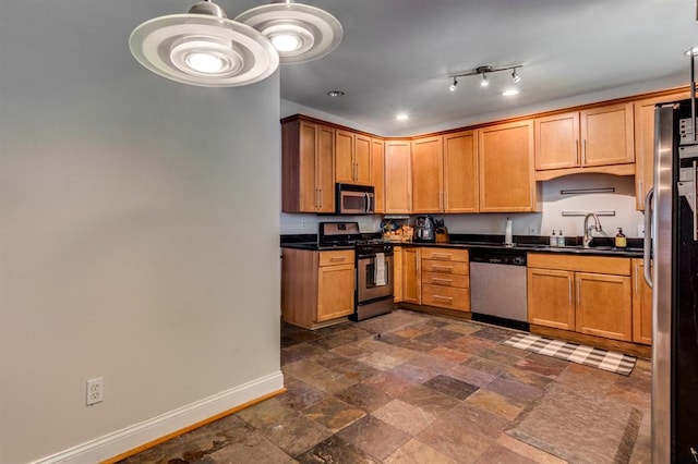2628 Indiana Ave, Saint Louis, MO 63118 - kitchen featuring appliances with stainless steel finishes, baseboards, dark countertops, a sink, and brown cabinetry