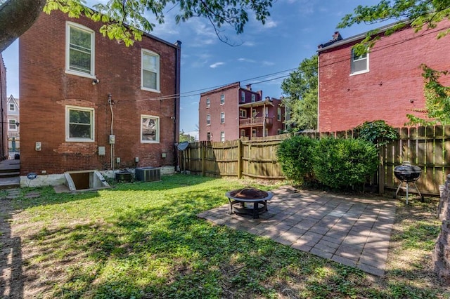 2628 Indiana Ave, Saint Louis, MO 63118 - rear view of house with an outdoor fire pit, brick siding, a patio, and central AC unit