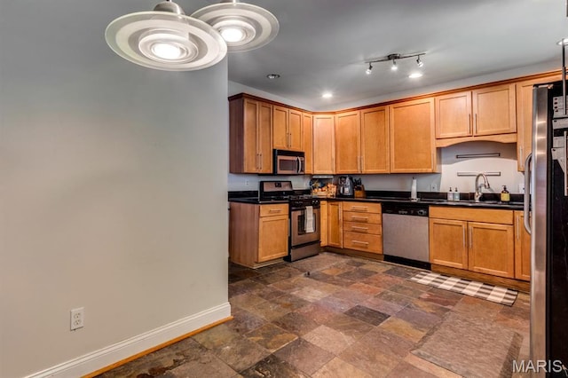 2628 Indiana Ave, Saint Louis, MO 63118 - kitchen featuring stainless steel appliances, baseboards, dark countertops, a sink, and dark stone finish floors
