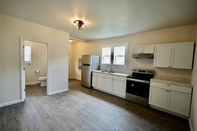 300 W Baker St, Gillespie, IL 62033 - kitchen featuring appliances with stainless steel finishes, under cabinet range hood, light countertops, a sink, and dark wood-style flooring