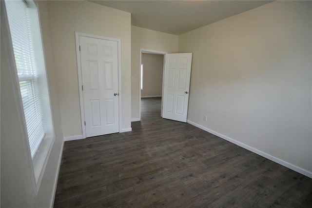 300 W Baker St, Gillespie, IL 62033 - unfurnished bedroom with baseboards and dark wood-type flooring