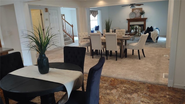 1059 Wolf Crk, Staunton, IL 62088 - carpeted dining room with stairs, a fireplace, ceiling fan, baseboards, and stone finish flooring