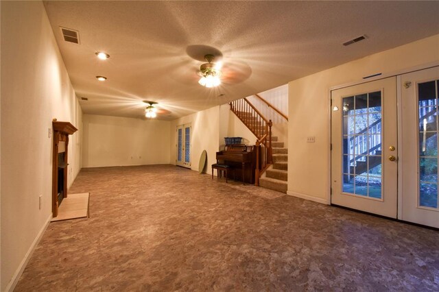 1059 Wolf Crk, Staunton, IL 62088 - unfurnished living room featuring ceiling fan, stairs, a fireplace with flush hearth, baseboards, and french doors