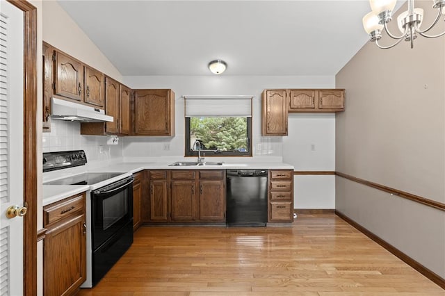 102 S Willow Grove Ct, Saint Peters, MO 63376 - kitchen with black appliances, a sink, under cabinet range hood, decorative backsplash, and light countertops
