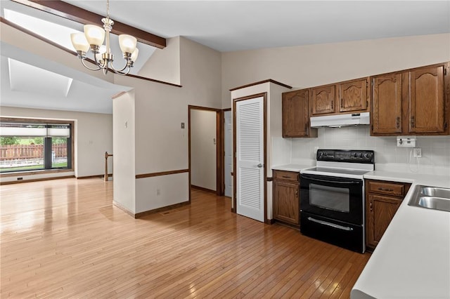 102 S Willow Grove Ct, Saint Peters, MO 63376 - kitchen with electric range oven, under cabinet range hood, light wood finished floors, light countertops, and a chandelier