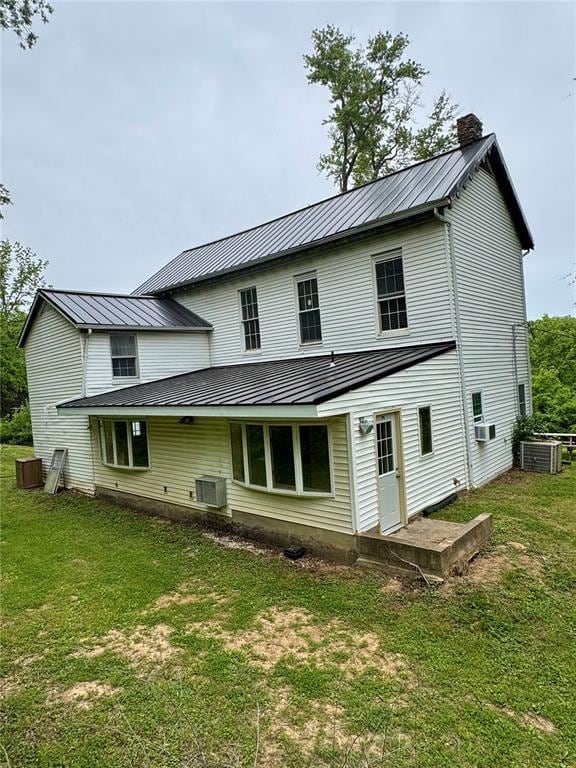 10321 Old 79, Hannibal, MO 63401 - rear view of property featuring a chimney, central air condition unit, metal roof, and a lawn
