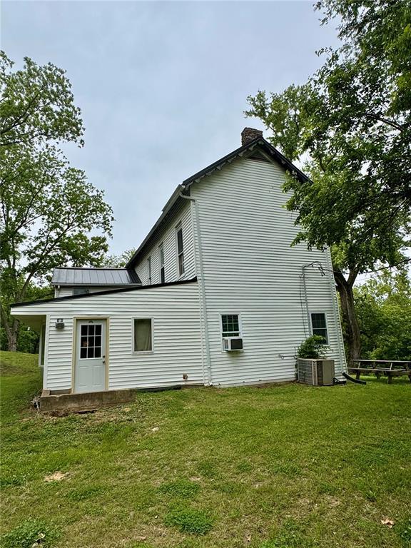 10321 Old 79, Hannibal, MO 63401 - rear view of house with a chimney, central air condition unit, a lawn, and cooling unit