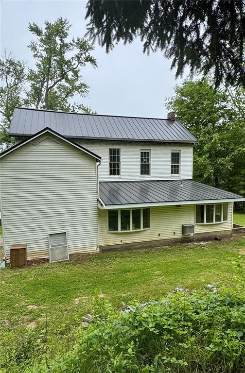 10321 Old 79, Hannibal, MO 63401 - back of property featuring a chimney, metal roof, a yard, and central AC