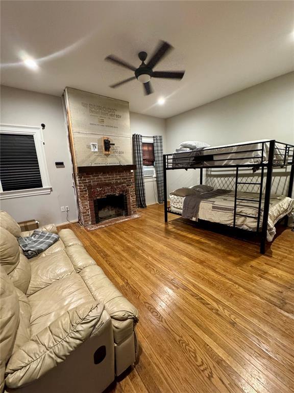 10321 Old 79, Hannibal, MO 63401 - bedroom with wood finished floors, a brick fireplace, and ceiling fan