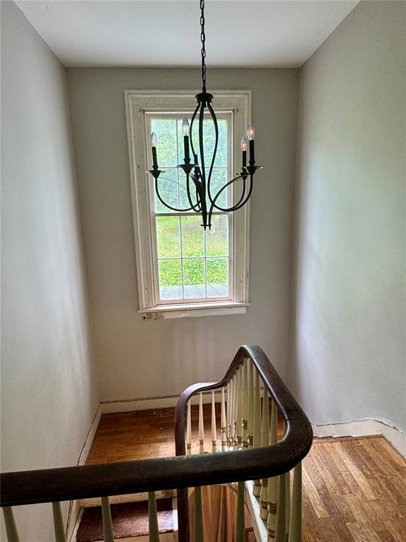 10321 Old 79, Hannibal, MO 63401 - staircase featuring wood finished floors, a chandelier, and baseboards