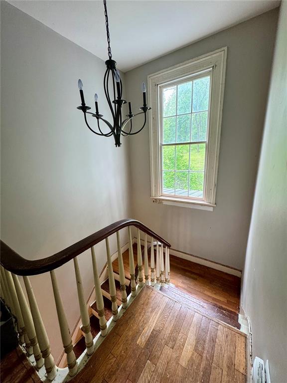 10321 Old 79, Hannibal, MO 63401 - stairway with a chandelier, hardwood / wood-style flooring, and baseboards
