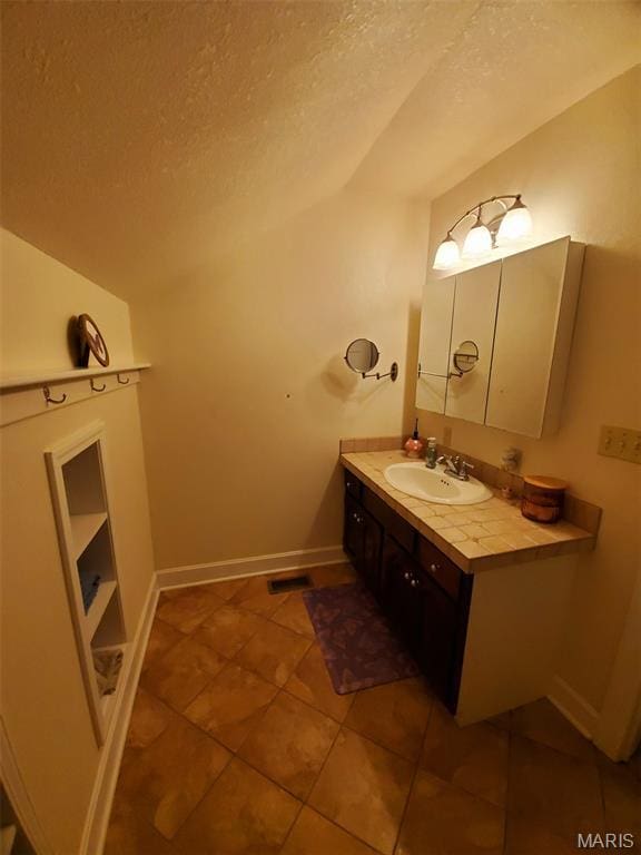 3 Janney Cir, Canton, MO 63435 - bathroom featuring lofted ceiling, a textured ceiling, vanity, tile patterned floors, and baseboards