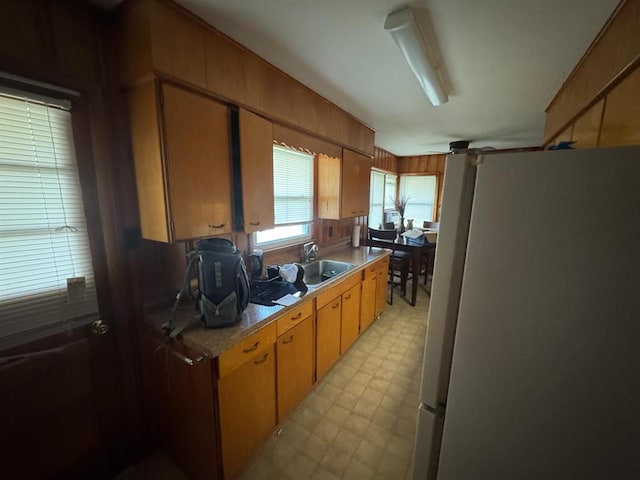 511 N 5th St, La Grange, MO 63448 - kitchen with freestanding refrigerator, a sink, light flooring, light countertops, and brown cabinets