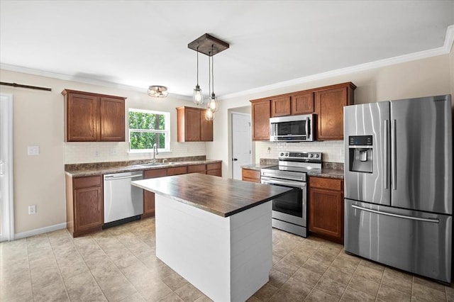 1406 Tisbury Cir, Ofallon, MO 63366 - kitchen featuring appliances with stainless steel finishes, a sink, decorative backsplash, crown molding, and a kitchen island