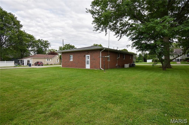 411 S Walnut St, Mount Olive, IL 62069 - view of side of home with a yard, brick siding, and central air condition unit