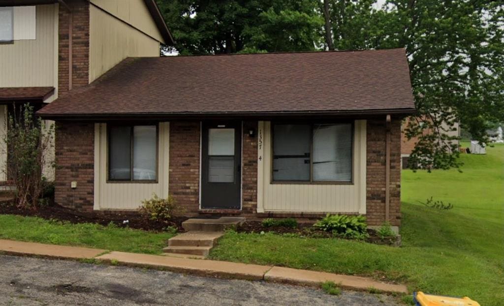 1357 Southwinds Dr Unit 4, Washington, MO 63090 - view of front of home featuring a shingled roof, brick siding, and a front lawn