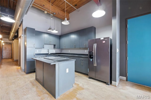 1312 Washington Ave Unit 2A, Saint Louis, MO 63103 - kitchen with stainless steel fridge with ice dispenser, a center island, light wood finished floors, and dark countertops