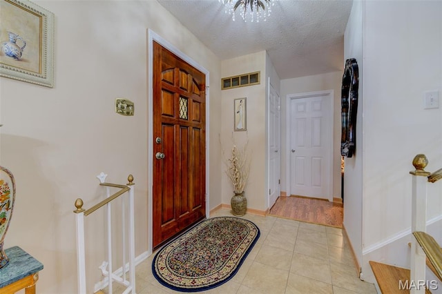 13556 Coliseum Dr, Chesterfield, MO 63017 - foyer entrance featuring light tile patterned floors, baseboards, and a textured ceiling
