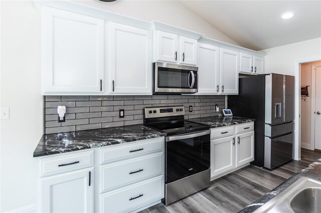 312 Andy Habsieger St, Festus, MO 63028 - kitchen with stainless steel appliances, lofted ceiling, dark wood-style flooring, white cabinetry, and decorative backsplash