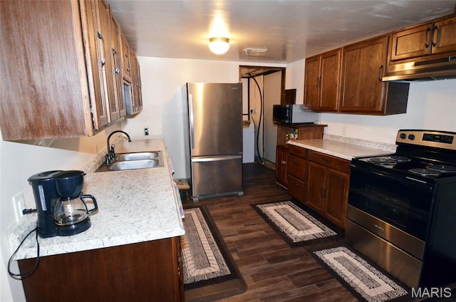 1116 E Springfield Rd, Sullivan, MO 63080 - kitchen featuring stainless steel appliances, under cabinet range hood, dark wood-type flooring, light countertops, and washer / dryer