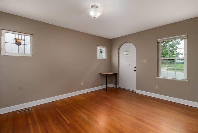 2447 Hartland Ave, Sycamore Hills, MO 63114 - entrance foyer with arched walkways, baseboards, and light wood-style flooring