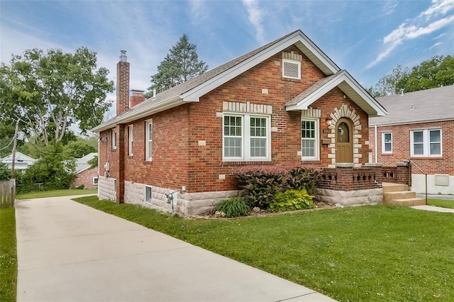 2447 Hartland Ave, Sycamore Hills, MO 63114 - view of front of house with a chimney, brick siding, a front lawn, and driveway