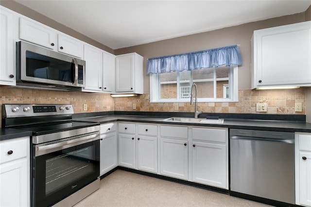 2447 Hartland Ave, Sycamore Hills, MO 63114 - kitchen featuring appliances with stainless steel finishes, a sink, dark countertops, and white cabinetry