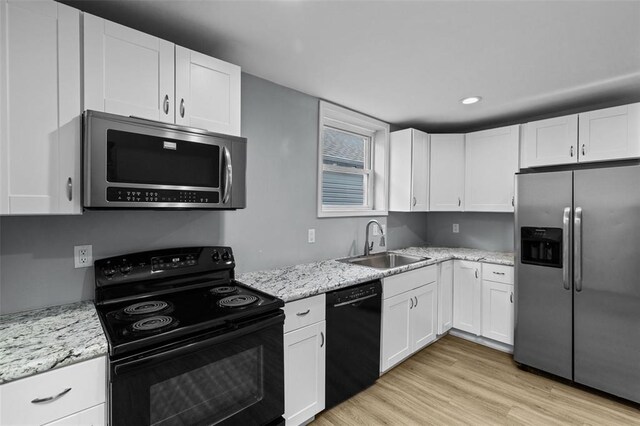 5337 Arsenal St, Saint Louis, MO 63139 - kitchen with black appliances, a sink, white cabinets, light wood-style floors, and light stone countertops