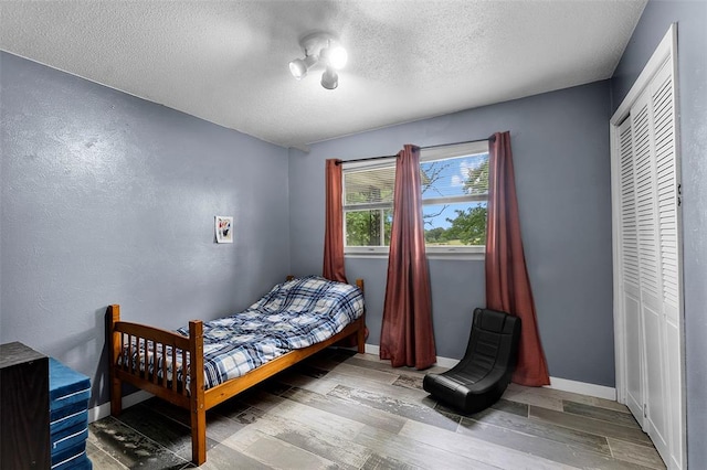 11454 State Highway 72, Millersville, MO 63766 - bedroom with a textured ceiling, wood finished floors, baseboards, and a closet