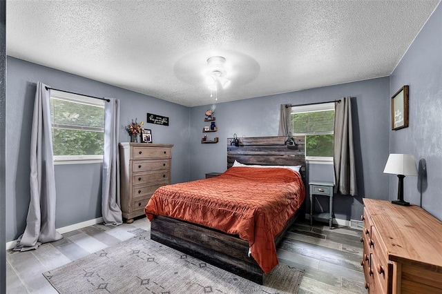 11454 State Highway 72, Millersville, MO 63766 - bedroom with multiple windows, wood finished floors, baseboards, a textured ceiling, and ceiling fan