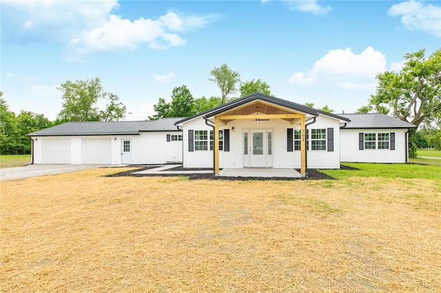 702 E Warren St, Bunker Hill, IL 62014 - rear view of property with a ceiling fan, asphalt driveway, a lawn, a garage, and metal roof
