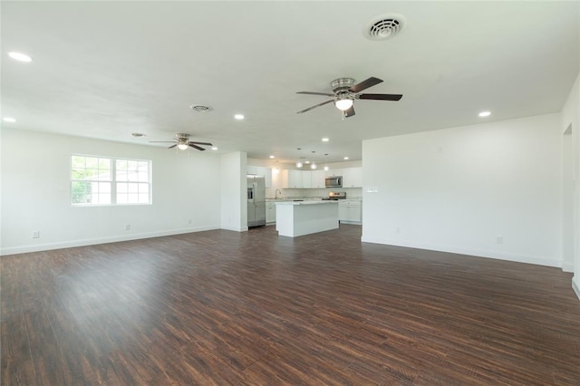 702 E Warren St, Bunker Hill, IL 62014 - unfurnished living room featuring a ceiling fan, recessed lighting, dark wood-style flooring, and baseboards