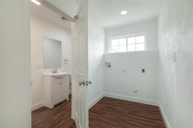 702 E Warren St, Bunker Hill, IL 62014 - laundry room featuring electric dryer hookup, dark wood-style flooring, a sink, and baseboards