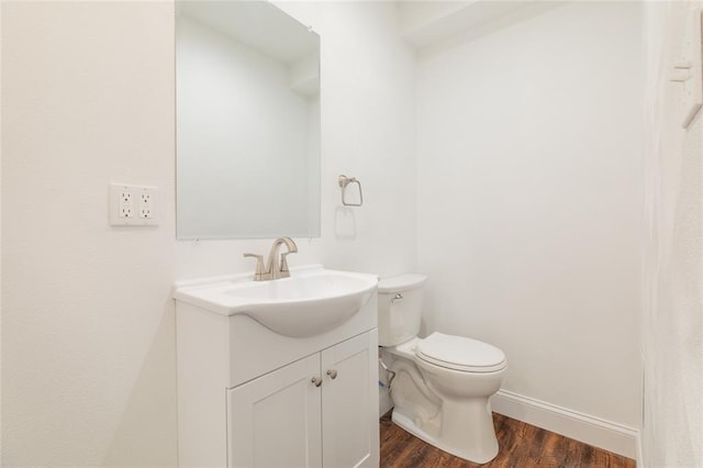 702 E Warren St, Bunker Hill, IL 62014 - half bath with wood finished floors, vanity, toilet, and baseboards