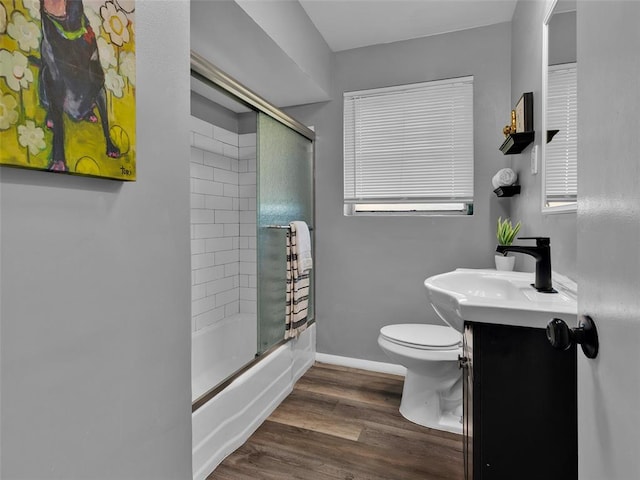 8668 Engler Ave, St John, MO 63114 - bathroom with vanity, toilet, bath / shower combo with glass door, wood finished floors, and baseboards