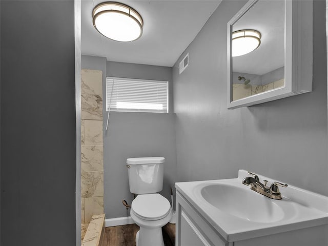 8668 Engler Ave, St John, MO 63114 - full bathroom with toilet, tiled shower, vanity, and wood finished floors