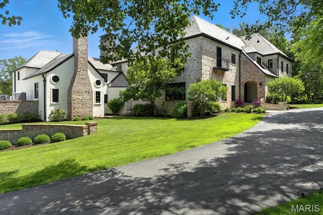 32 Woodoaks Trl, Ladue, MO 63124 - french provincial home featuring a chimney, stone siding, a front lawn, and stucco siding